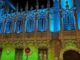 Fachada gótica del edificio municipal de Albacete iluminada con luces azules y verdes durante la noche para concienciar sobre la Hipertensión Intracraneal Idiopática